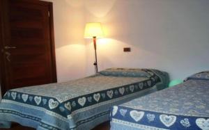 a hotel room with two beds and a lamp at Rosa Dei Venti in Moggio Udinese