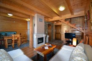 a living room with a fireplace in a log cabin at Holiday Homes Durmitorski Gaj in Žabljak