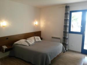 a bedroom with a bed with two pillows and a window at Le Provence in Manosque