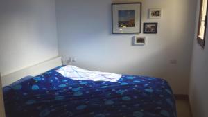 Schlafzimmer mit blauer Decke auf einem Bett in der Unterkunft Casa Muffin 3 in Cannobio