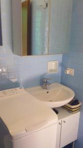 ein Badezimmer mit einem weißen Waschbecken und einem Spiegel in der Unterkunft Casa Muffin 3 in Cannobio