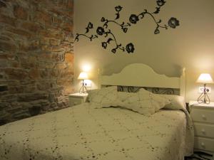 a bedroom with a bed with a branch on the wall at Casa Maria in Salamir