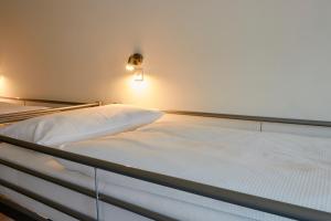 an empty bed in a room with a light at Ballhaus Berlin Hostel in Berlin