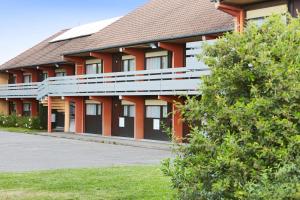 a building with red columns and a brown roof at Campanile Colmar - Parc des Expositions in Colmar