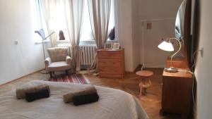 sypialnia z łóżkiem, krzesłem i oknem w obiekcie Apartament pod Piernikiem w Toruniu