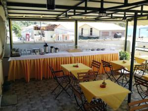 a restaurant with tables and chairs and a counter at Sundy's Studios in Nydri