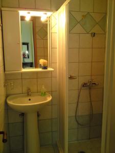 a bathroom with a sink and a shower with a mirror at Sundy's Studios in Nydri