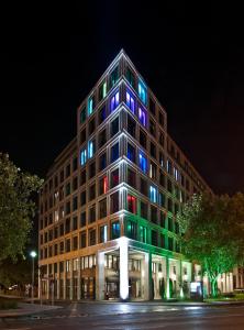 a building with colorful lights on the side of it at COSMO Hotel Berlin Mitte in Berlin