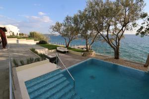 una piscina junto al océano con una escalera en Hotel Vila 4m, en Ražanac