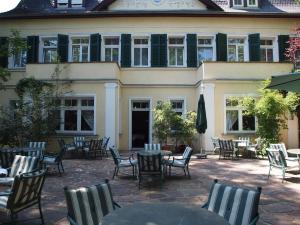 Hotel & Restaurant Bellevue Schmölln في Schmölln: فناء فيه طاولات وكراسي امام مبنى