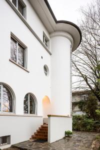 Una casa blanca con un arco a un lado. en Fribauhaus, en Fribourg