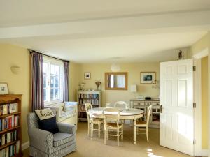 a living room with a table and a kitchen at Ogilvie Lodge Apartment in Thorpeness