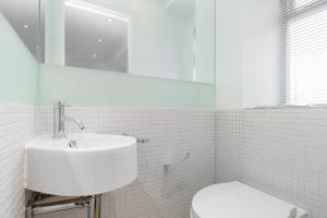 a white bathroom with a sink and a toilet at Apartment near Harrods in London