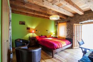 1 dormitorio con cama y pared verde en Casa Dorondón, en Lasaosa