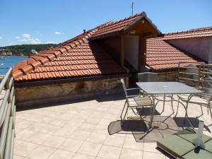 eine Terrasse mit einem Tisch und Stühlen auf dem Dach in der Unterkunft Apartment Marija in Tisno
