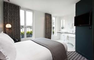 a bedroom with a bed and a bathroom with a tub at Hôtel Emile Le Marais in Paris +19 photos