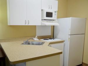 a small kitchen with a sink and a microwave at Extended Stay America Suites - Huntsville - US Space and Rocket Center in Huntsville