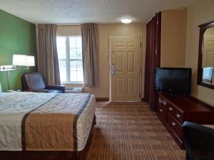 a hotel room with a bed and a flat screen tv at Extended Stay America Suites - Huntsville - US Space and Rocket Center in Huntsville