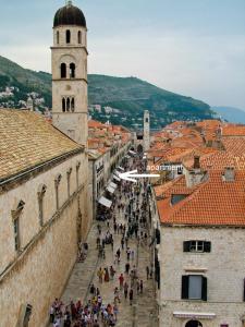 a crowd of people walking down a street between buildings at Festa Stradun Apartment in Dubrovnik