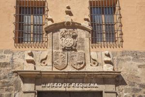
a stone building with a clock on the front of it at Alojamiento Turístico La Tinaja in Requena
