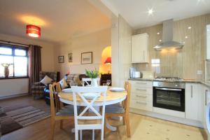 cocina y sala de estar con mesa y comedor en Sheneval Apartment en Inverness