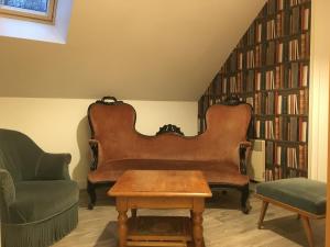 two chairs and a table in a room with bookshelves at le petit clos in Baugé-en-Anjou