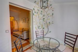 a dining room with a glass table and a couch at Braga Sarmiento Apartment in Braga