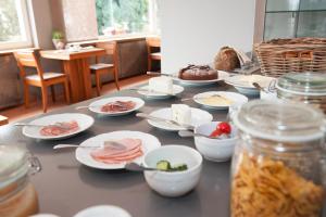 einen Tisch mit Teller mit Lebensmitteln darüber in der Unterkunft Hotel Fiori in Bad Soden-Salmünster