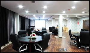 una sala de conferencias con sillas y una mesa con flores. en Taraf Yanbu, en Yanbu