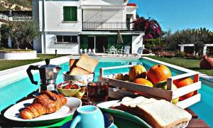 un tavolo con vassoio di pane e frutta accanto alla piscina di Villa Paola a Grottammare