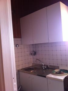uma cozinha com um lavatório e paredes em azulejos brancos em La Tela Di Penelope em San Marco dʼAlunzio
