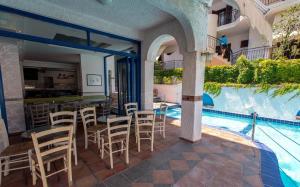 a swimming pool with a table and chairs next to a house at Golden Beach Potidea in Nea Potidaea