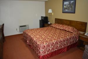 ein Schlafzimmer mit einem Bett in einem Hotelzimmer in der Unterkunft Travelers Inn in New Martinsville