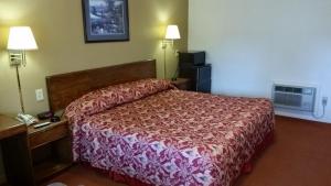 ein Hotelzimmer mit einem Bett und einem Telefon in der Unterkunft Travelers Inn in New Martinsville