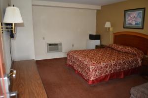 a hotel room with a bed and a couch at Travelers Inn in New Martinsville