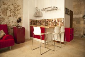 アヴィニョンにあるCité des Papesの赤いキャビネット付きのキッチン、白い椅子付きのバー