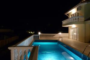 a swimming pool in front of a house at night at Villa Sorento Italian NeoClassica in Balchik