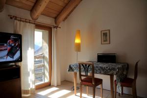 a room with a table and a television and a window at Casa Dosc in Verdabbio