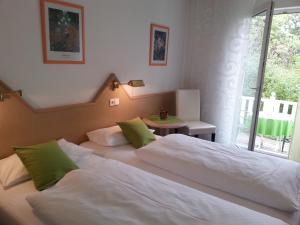 a bedroom with two beds and a table and a window at Hotel Garni Sand in Tübingen