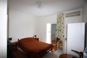a bedroom with a bed and a desk and a window at Miloi Rooms and Apartments in Míloi
