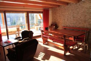 a dining room with a wooden table and benches at Holiday Home Edi in Delnice