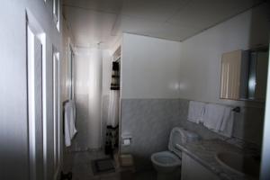 a white bathroom with a toilet and a sink at Miloi Rooms and Apartments in Míloi +92 photos