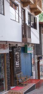 una mesa y sillas sentadas fuera de un edificio en The Tayta Hostal en Machu Picchu