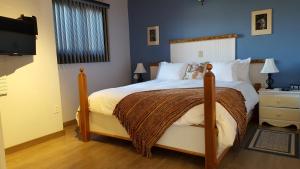 sypialnia z dużym łóżkiem i telewizorem w obiekcie Duck Pond B&B Cottage w mieście Leamington