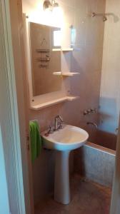 y baño con lavabo, espejo y bañera. en Cabaña Anfuso en San Rafael