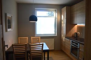 eine Küche mit Tisch und Stühlen und einem Fenster in der Unterkunft Apartament Wanilia i Goździk in Szczawnica