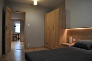 a bedroom with a bed and a wooden headboard at Apartament Cynamon ,Wanilia i Goździk in Szczawnica