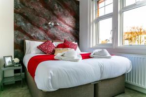a bedroom with a large bed with red and white pillows at Meads Apartment in Eastbourne
