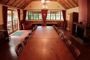 Großes Zimmer mit einem langen Tisch und Stühlen in der Unterkunft Vineyard Cottages - Kumeu in Waimauku