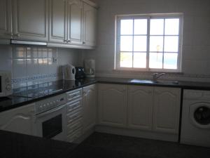 a kitchen with white cabinets and a sink and a window at GUADALUPE 3 in Luz